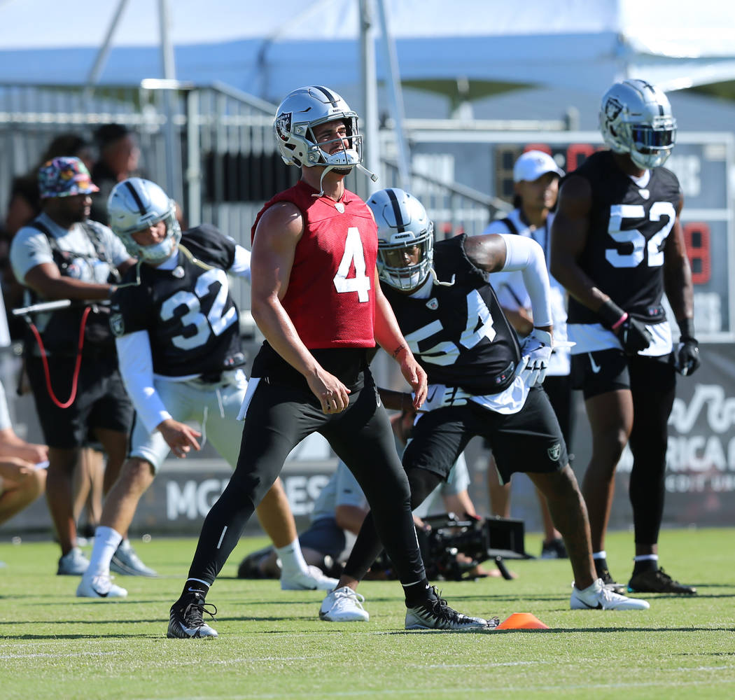 Oakland Raiders quarterback Derek Carr (4) stretches in front of safety Dallin Leavitt (32), in ...