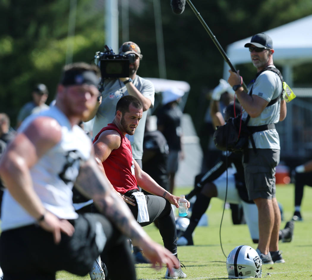 The HBO Hard Knocks crew film Oakland Raiders quarterback Derek Carr (4) as he stretches during ...