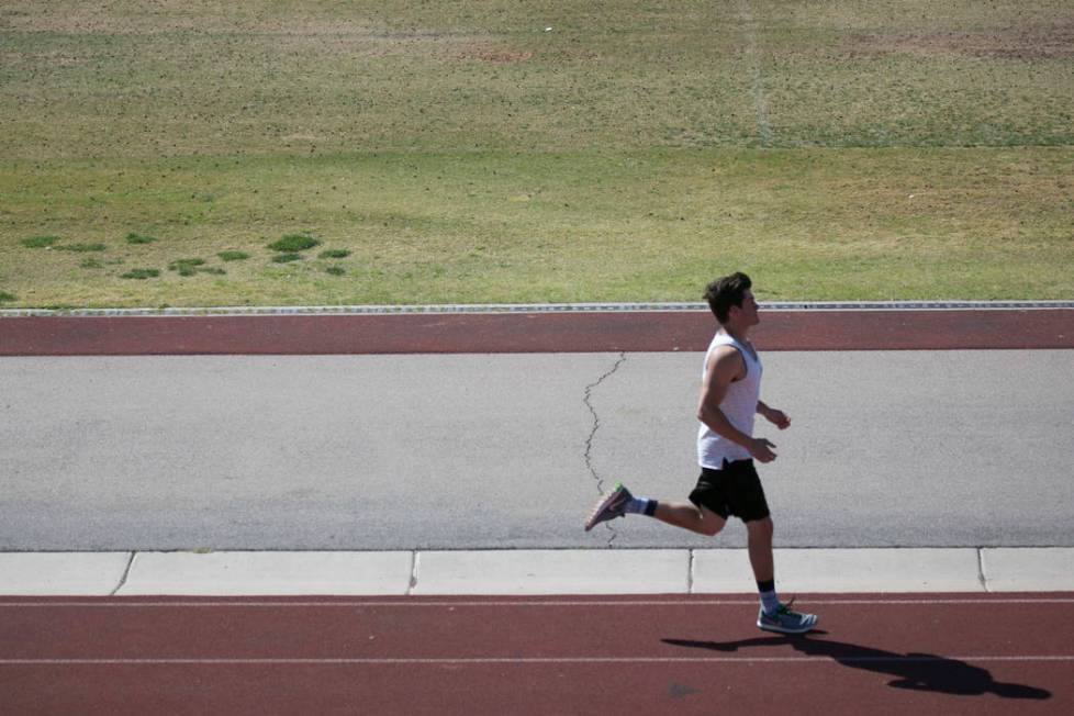 Edward &quot;Teddy&quot; Andrews warms up prior to pole vaulting during a track and ...