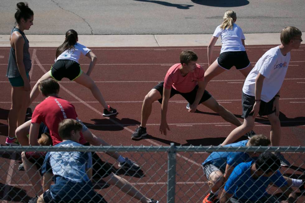 Garett Furlong, center, warms up with teammates during a track and field practice at Coronad ...