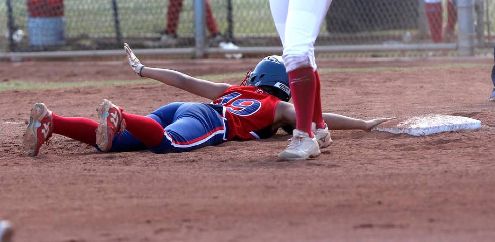 Liberty’s Alyssa Tolentino (19) dives for third base after attempting to steal during ...