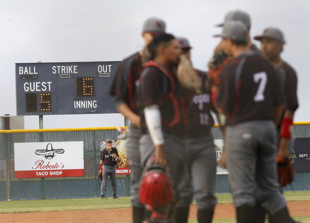 Las Vegas players huddle on the mound during the sixth inning of a high school baseball game ...