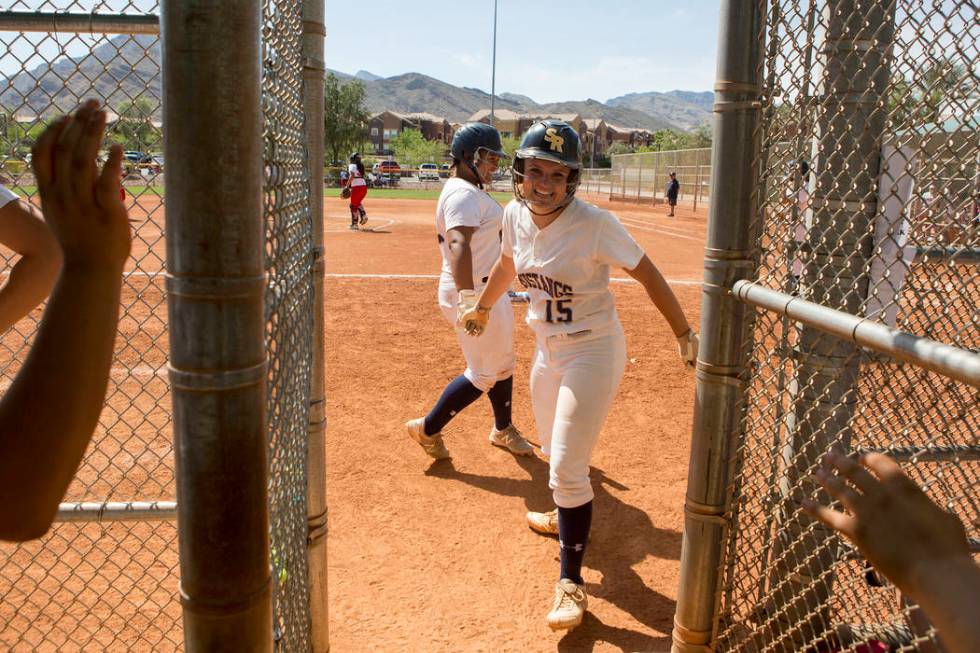 Shadow Ridge teammates congratulate junior Mia Voges after her run during a game against Ban ...