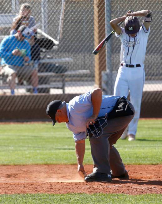 An umpire dusts off home plate as Cimarron-Memorial’s Jackson Folkman (6) approaches t ...