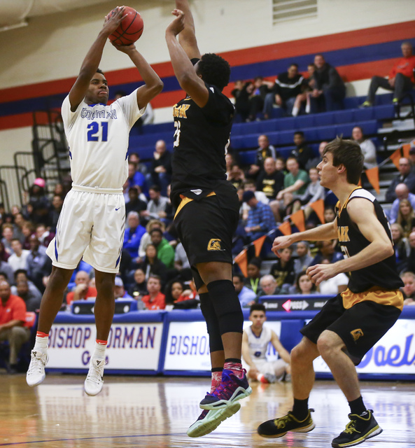 Bishop Gorman guard Christian Popoola (21) shoots over Clark forwards Antwon Jackson (23) an ...