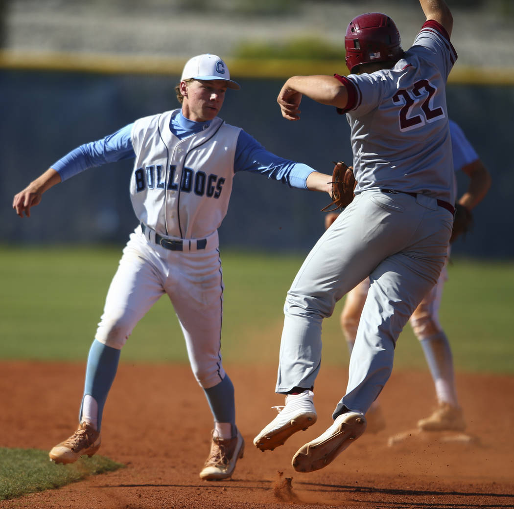 Centennial’s Kian Wilbur tags out Desert Oasis’ Chaison Miklich (22) between fir ...