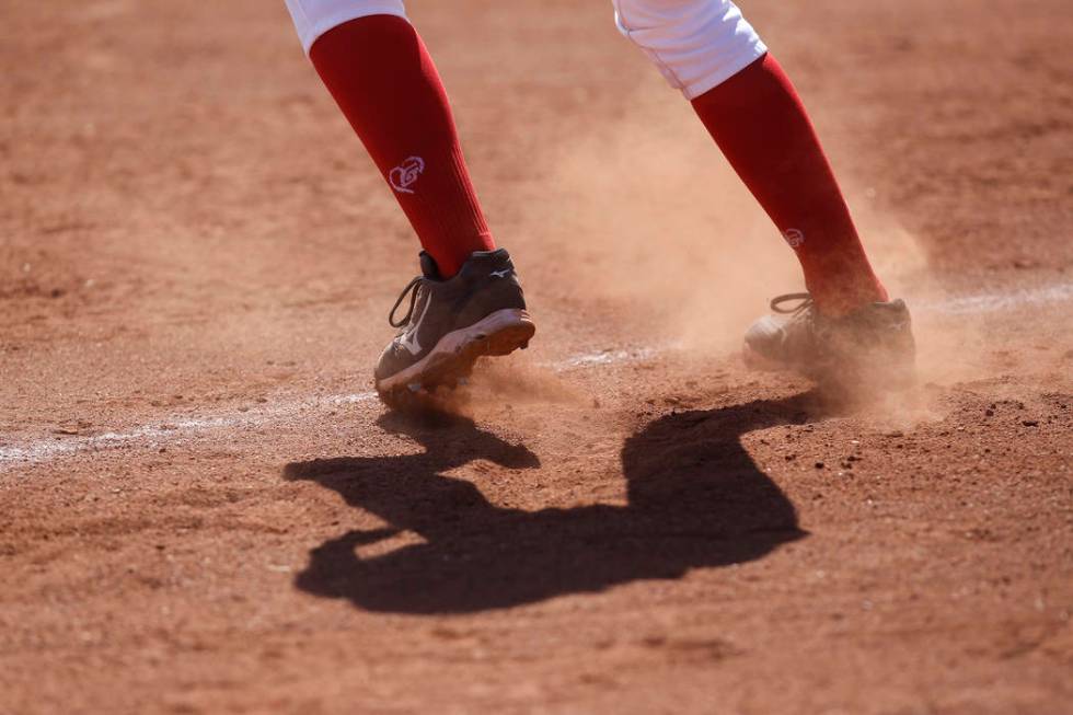 Dust flies as a player leads off third base during a high school softball game at Coronado H ...