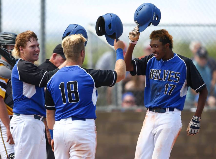 Basic’s Garrett Giles (17) celebrates his home run with Jack Wold, left, and Trace Eva ...