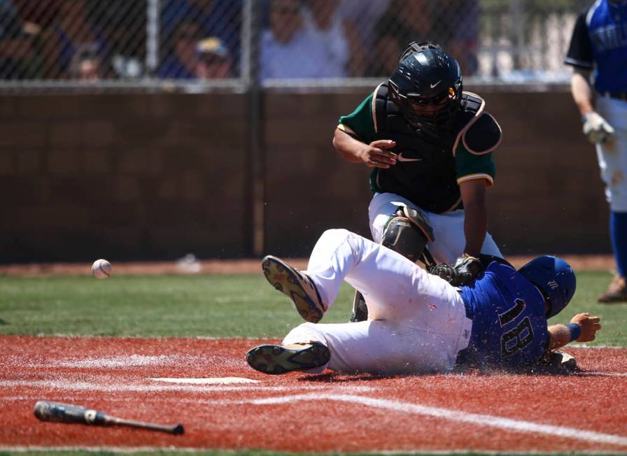 Basic’s Trace Evans (18) slides into home base to score a run as Rancho’s Miguel ...