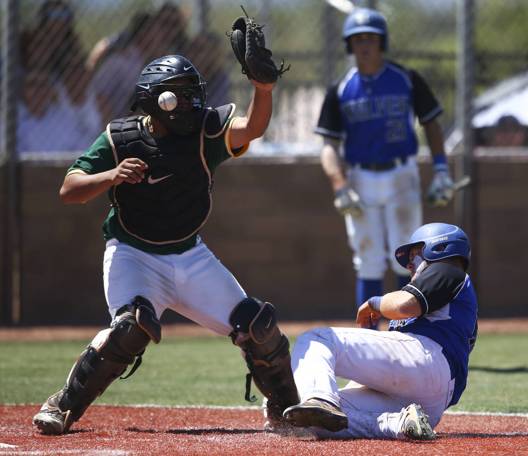 Basic’s Trace Evans slides into home base to score a run as Rancho’s Miguel Elic ...