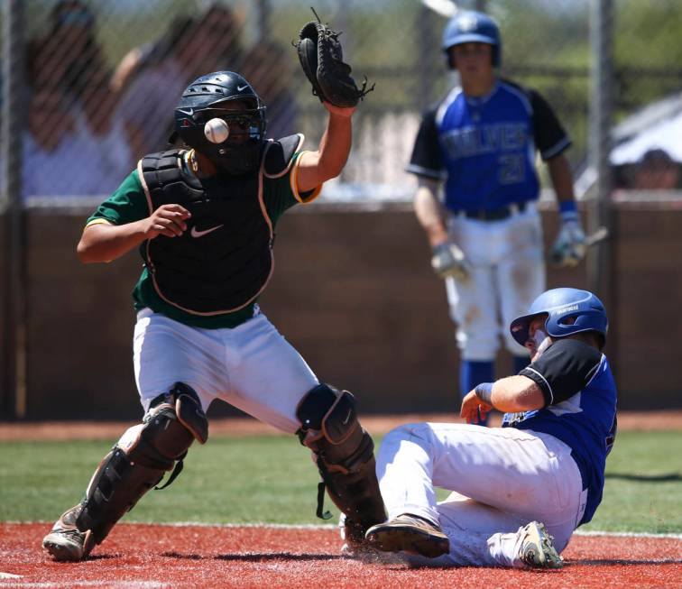 Basic’s Trace Evans slides into home base to score a run as Rancho’s Miguel Elic ...