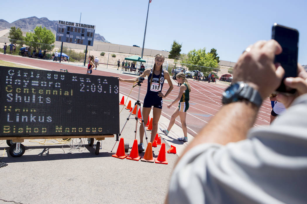 Centennial senior Karina Haymore takes a picture with her time after the girls 800-meeter ru ...