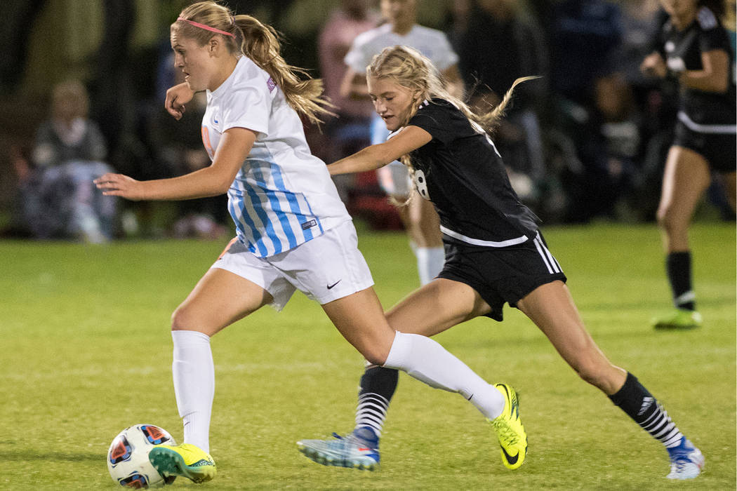 Arlie Jones (19), from Bishop Gorman High School, battles for the ball against Alexis Lloyd ...