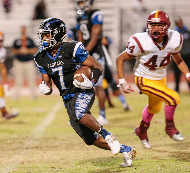 Desert Pines senior Isaiah Morris (7) runs the ball down the field as Del Sol sophomore Ati ...