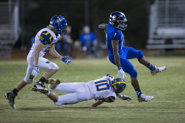 Desert Pines running back Isaiah Morris (7) leaps over a tackle attempt by Moapa Valley&#821 ...