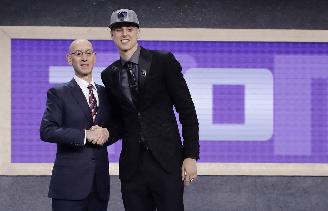 Zach Collins poses for photos with NBA Commissioner Adam silver after being selected by the ...