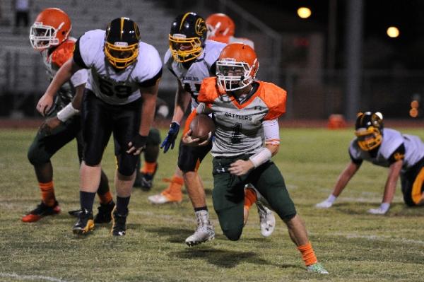 Mojave quarterback Zack Arave races past Boulder City defensive tackle Andrew Sands (59) and ...