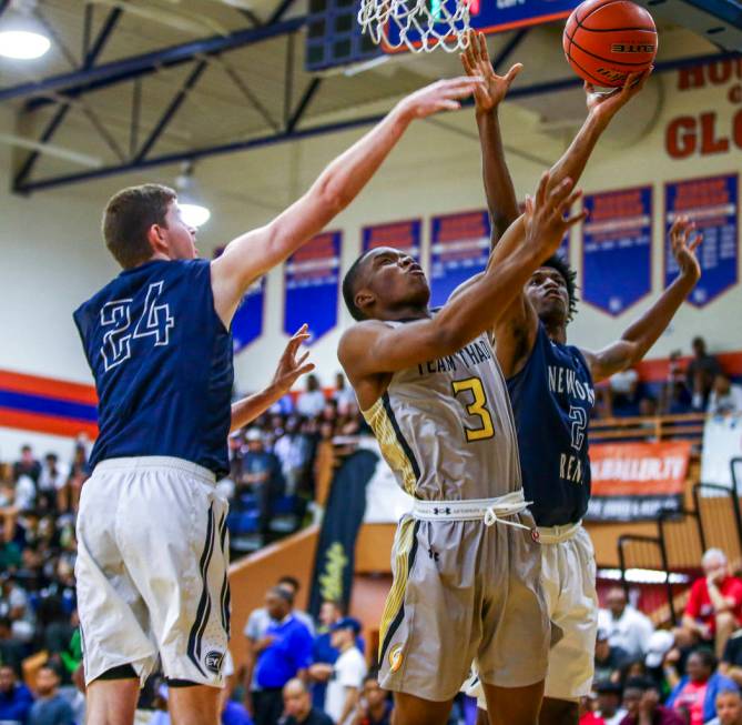 Team Thad’s Tavin Lovan attempts a layup against New York defenders Sloan Seymour, lef ...