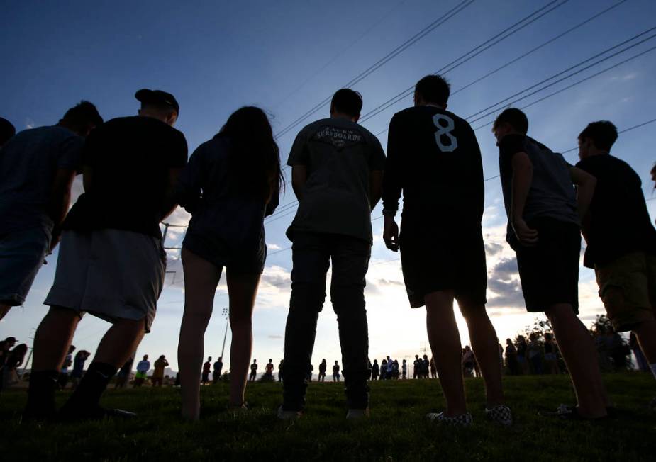 People stand in a circle during a vigil for Haylei Hughes, a former Cimarron-Memorial studen ...