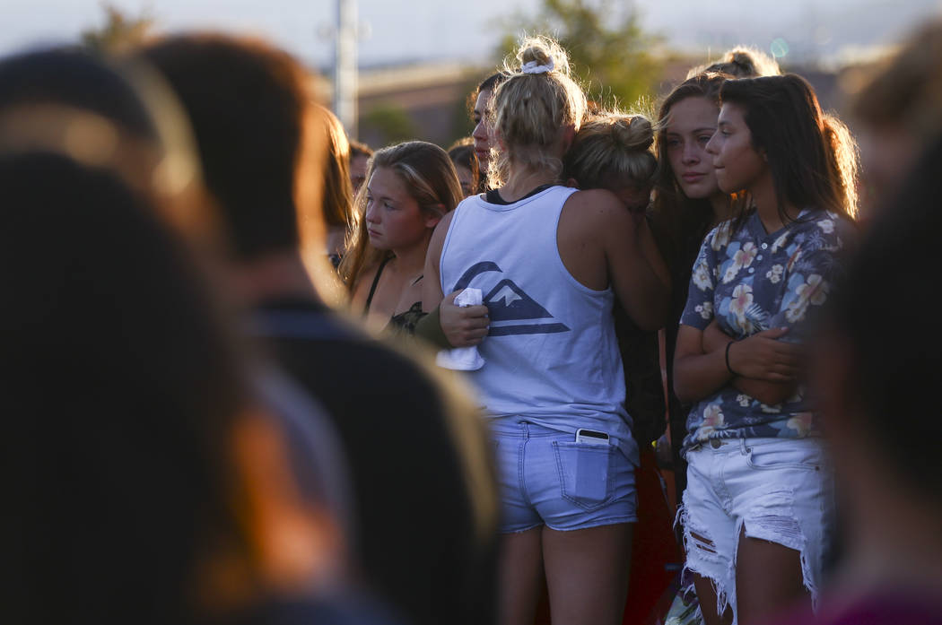 People embrace during a vigil for Haylei Hughes, a former Cimarron-Memorial student-athlete, ...