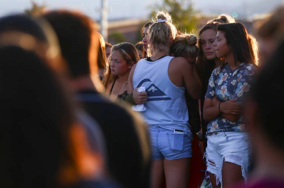 People embrace during a vigil for Haylei Hughes, a former Cimarron-Memorial student-athlete, ...