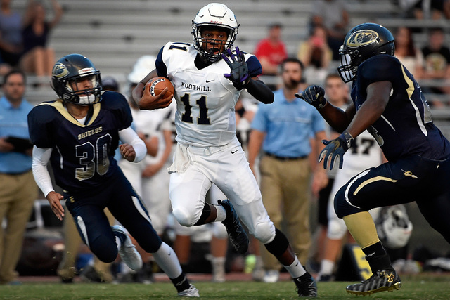 Foothill quarterback Jordan Wilson carries the ball against Cheyenne’s Joseph Kunicki ...