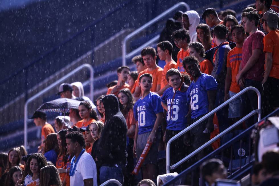 Fans sit in the rain during a delay at the Bishop Gorman versus Miami Central football game ...