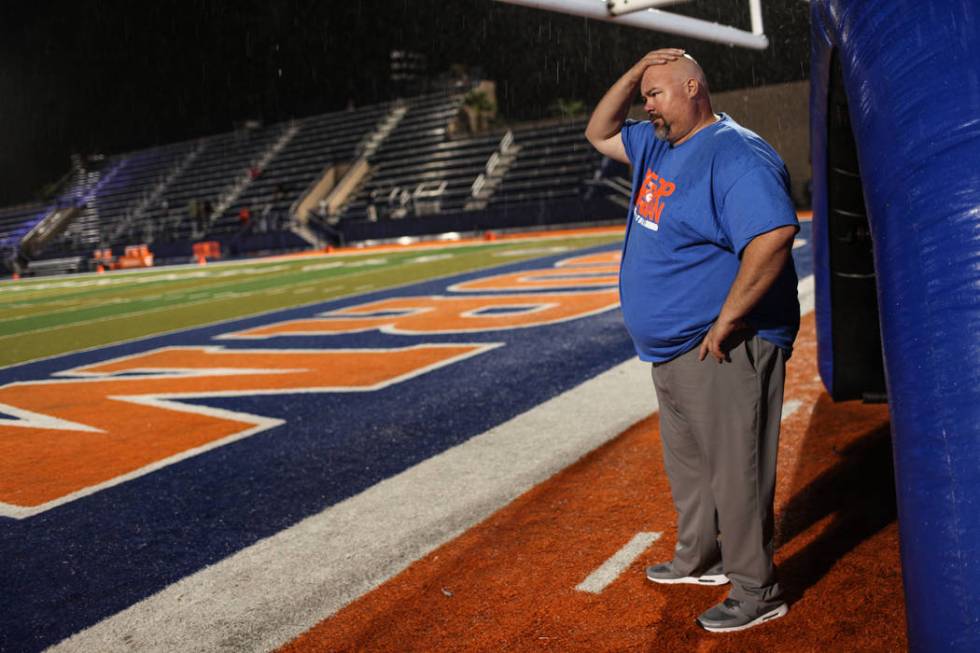 Bishop Gorman Assistant Coach Scott Cooley rubs his head during a delay at the Bishop Gorman ...