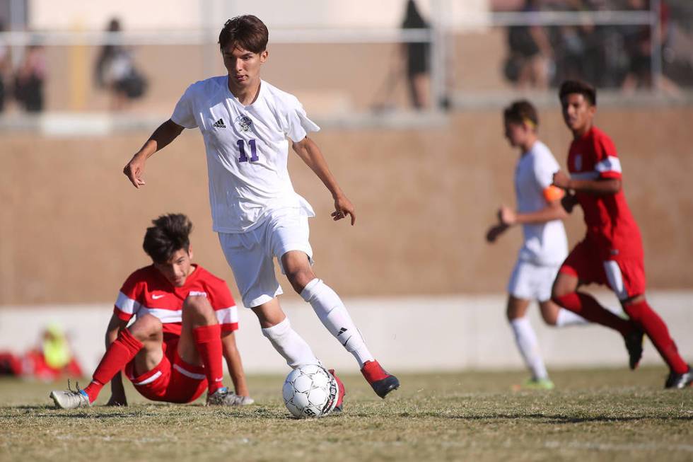 Sunrise Mountain player Felipe Lucero (11) dribbles the ball as Western player Jesse Vidales ...