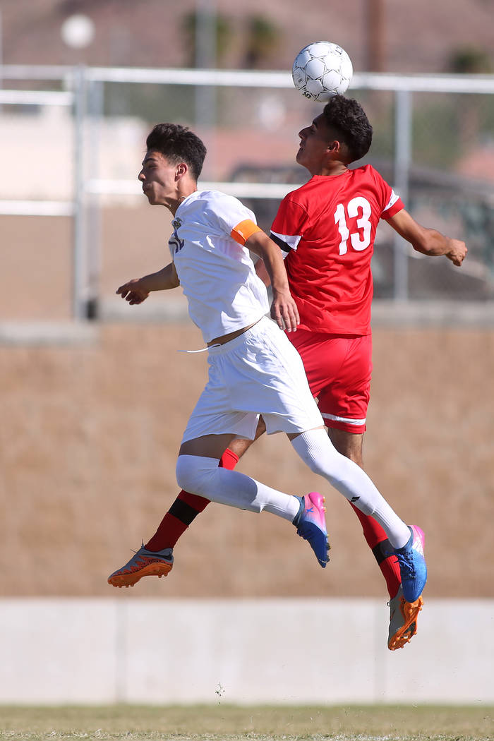 Western player Ismael Navarro (13) heads the ball as Sunrise Mountain player Bryan Martinez ...