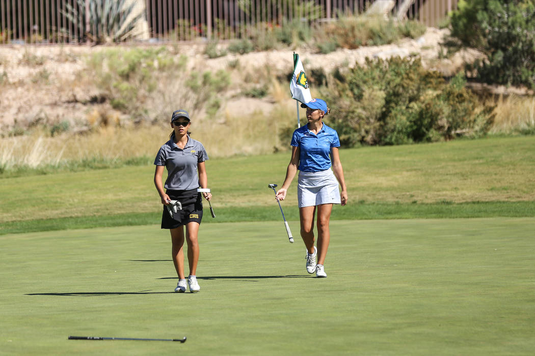 Clark’s Riana Mission, left, and Bishop Gorman’s Hunter Pate, right, walk during ...