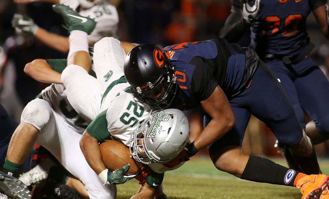 Bishop Gorman player Palaie Gaoteote (10) tackles De La Salle player Kairee Robinson (25) du ...