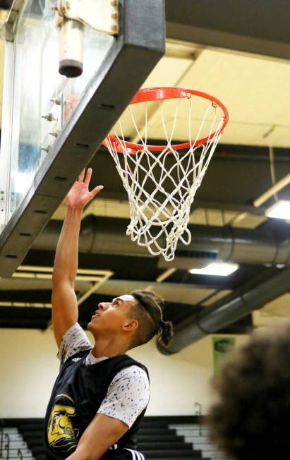 Clark High School senior Greg Foster completes a lay up during basketball practice at Clark ...