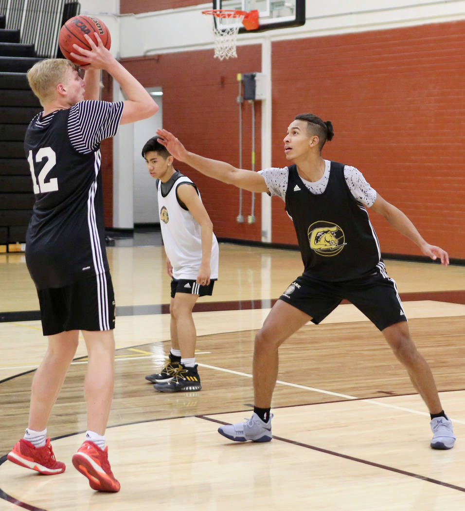 Trey Woodbury, 12, shoots while Greg Foster guards during basketball practice at Clark High ...