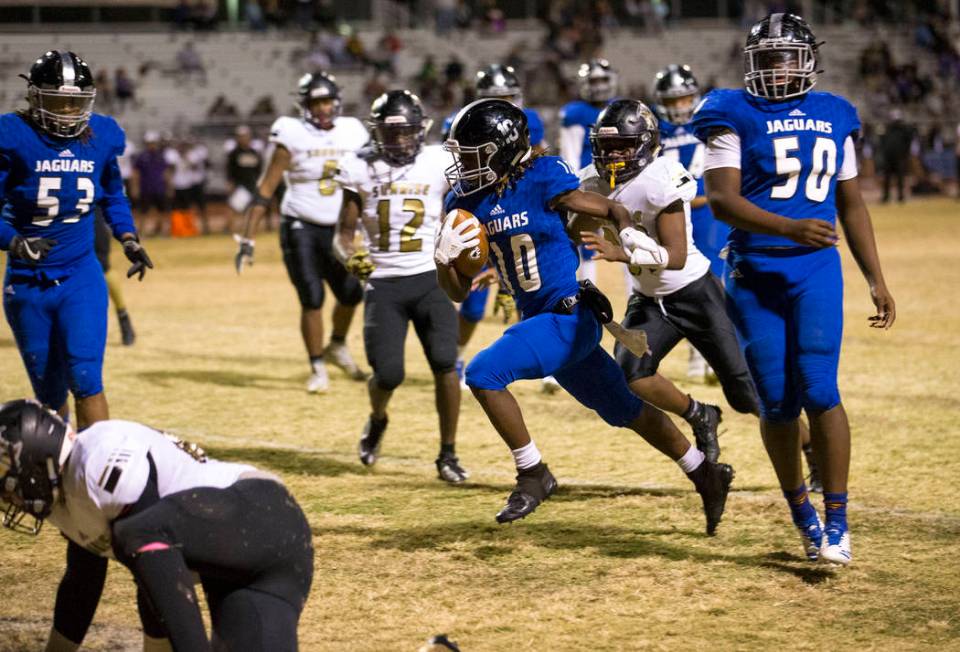 Desert Pines running back Devin McGee (10) breaks through Sunrise Mountain defenders for a t ...