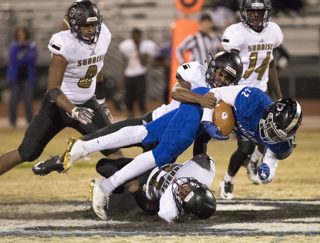 Desert Pines running back Jyden King (12) is brought down by Sunrise Mountain defenders duri ...