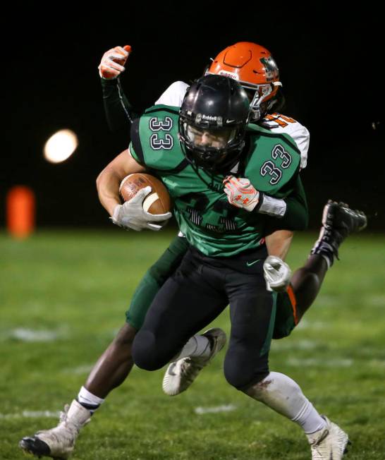 Virgin Valley’s Jayden Perkins (33) is tackled by Mojave’s Noah Thompson (10) du ...