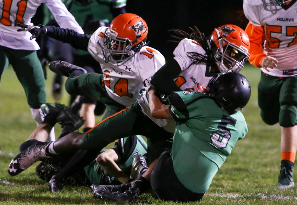 Mojave’s Noah Thompson (10) is tackled by Virgin Valley’s Carlos Pacheco (5) dur ...