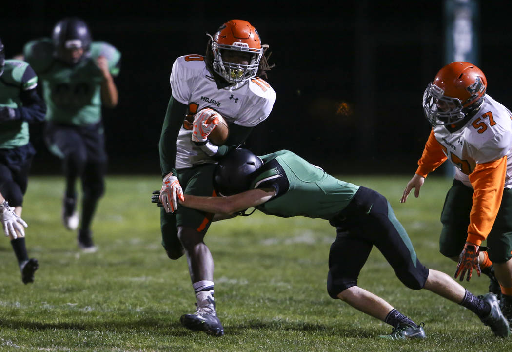 Mojave’s Noah Thompson (10) is tackled by Virgin Valley’s Carlos Pacheco (5) dur ...