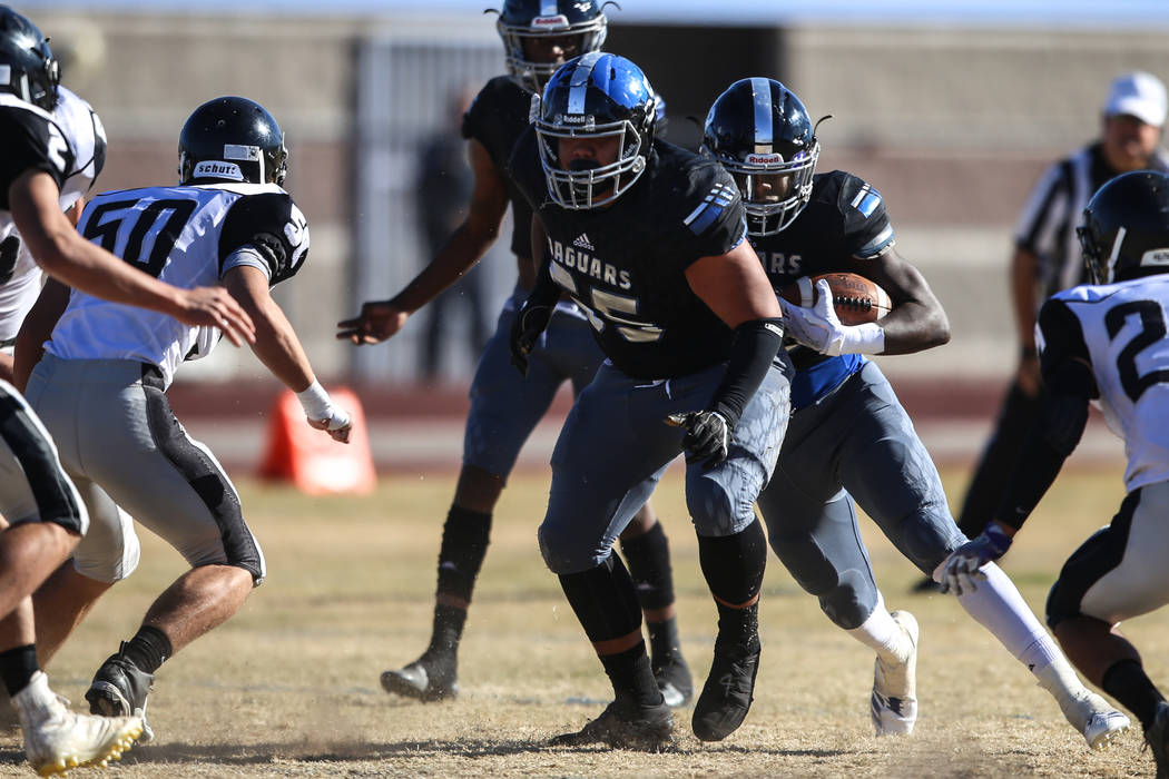 Desert Pines’s Jyden King (12), right, runs the ball against Spring Creek during the f ...