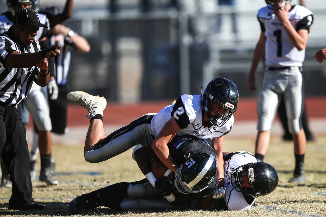 Desert Pines’ Michael Lofton (15), center, is tackled by Spring Creek during the first ...