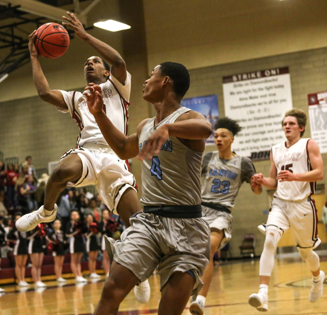 Desert OasisՠKamari Burnside (0), left, jumps as he shoots a layup against Canyon Spri ...