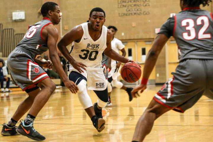 Democracy Prep’s Daniel Plummer (30), center, dribbles the ball past Arbor View’ ...