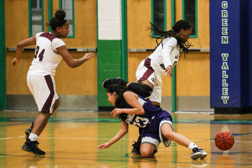 Cimarron-Memorial’s Amoura Whitney (33) jumps over Spanish Springs’ Serena Sanch ...