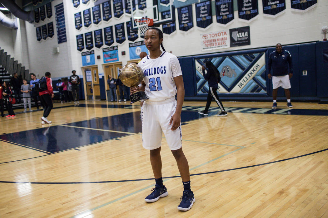 Centennial’s Justice Ethridge (21) holds an MVP trophy after defeating Etiwanda 59-39 ...