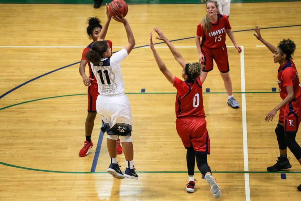 Spring Valley’s Kayla Harris (11) shoots the ball as Liberty’s Rane Burrell (0) ...