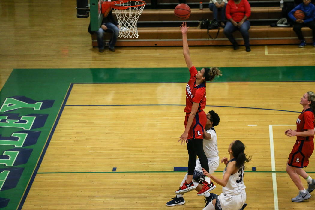 Liberty’s Rane Burrell (0) shoots the ball as she is guarded by Spring Valley’s ...