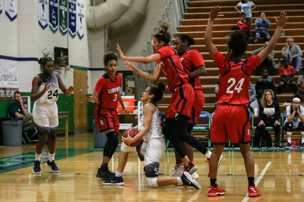 Spring Valley’s Essence Booker (3) holds the ball as Liberty’s Rane Burrell (0) ...