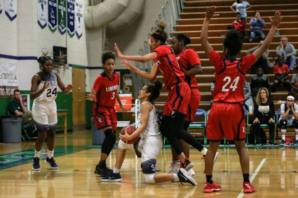 Spring Valley’s Essence Booker (3) holds the ball as Liberty’s Rane Burrell (0) ...