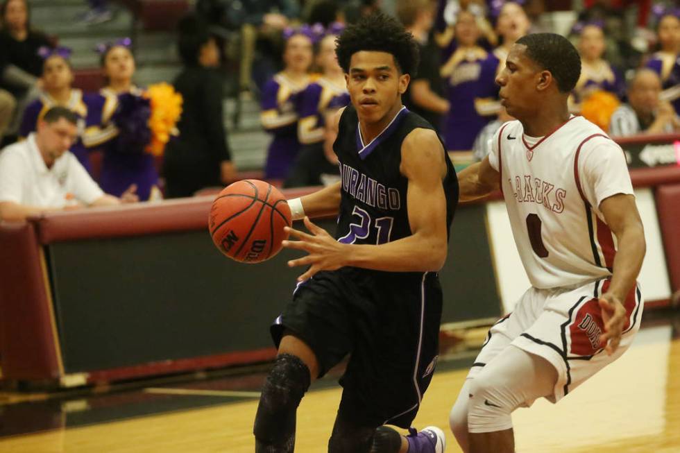 Desert Oasis player Kamari Burnside (0) guards Durango player Anthony Hunter (21) as he driv ...